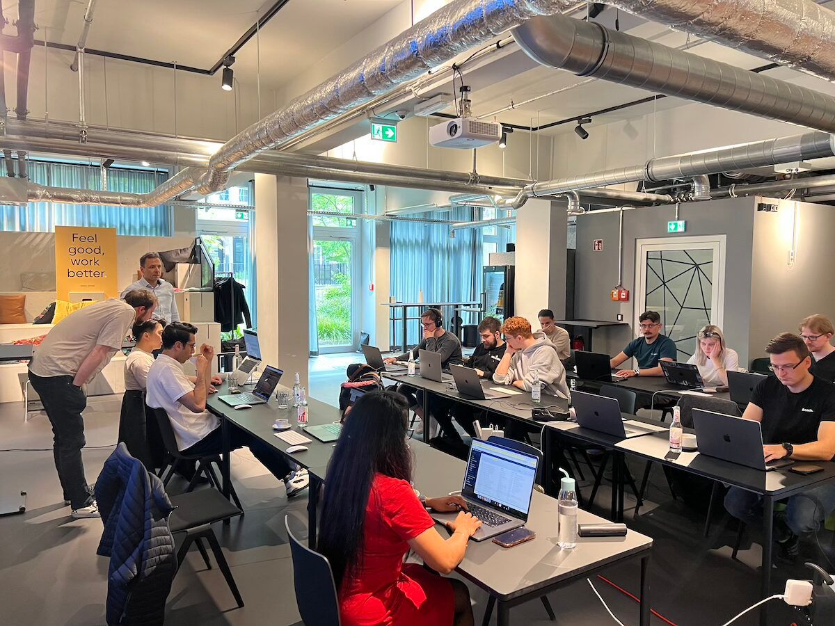 Das Team von codeitlabs im Münchner Büro, an Schreibtischen mit Laptops